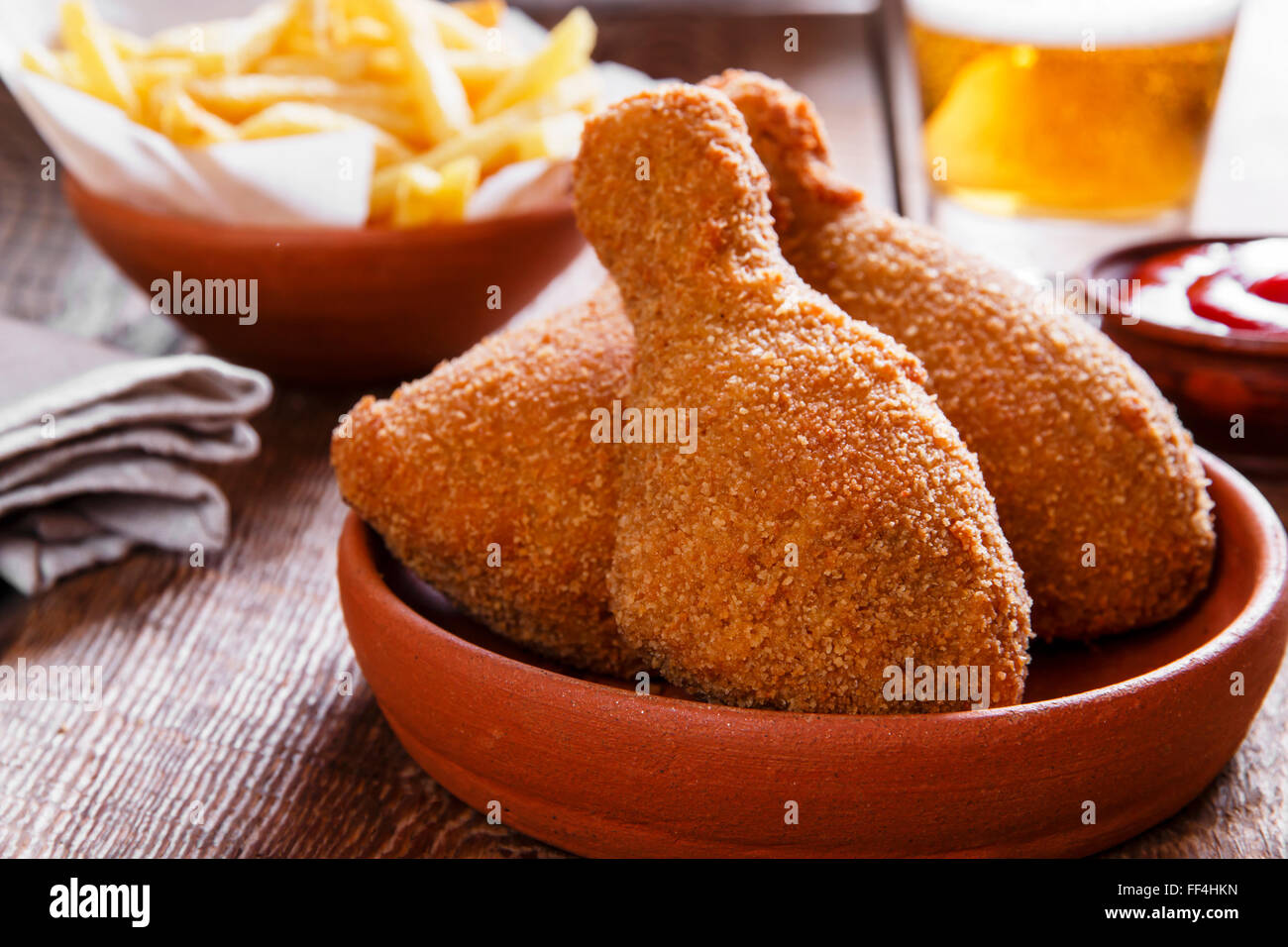 fried chicken leg in breadcrumbs and french fries Stock Photo
