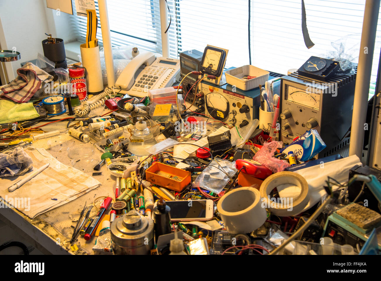 messy table with tools and all sort of technical parts at repair shop Stock Photo