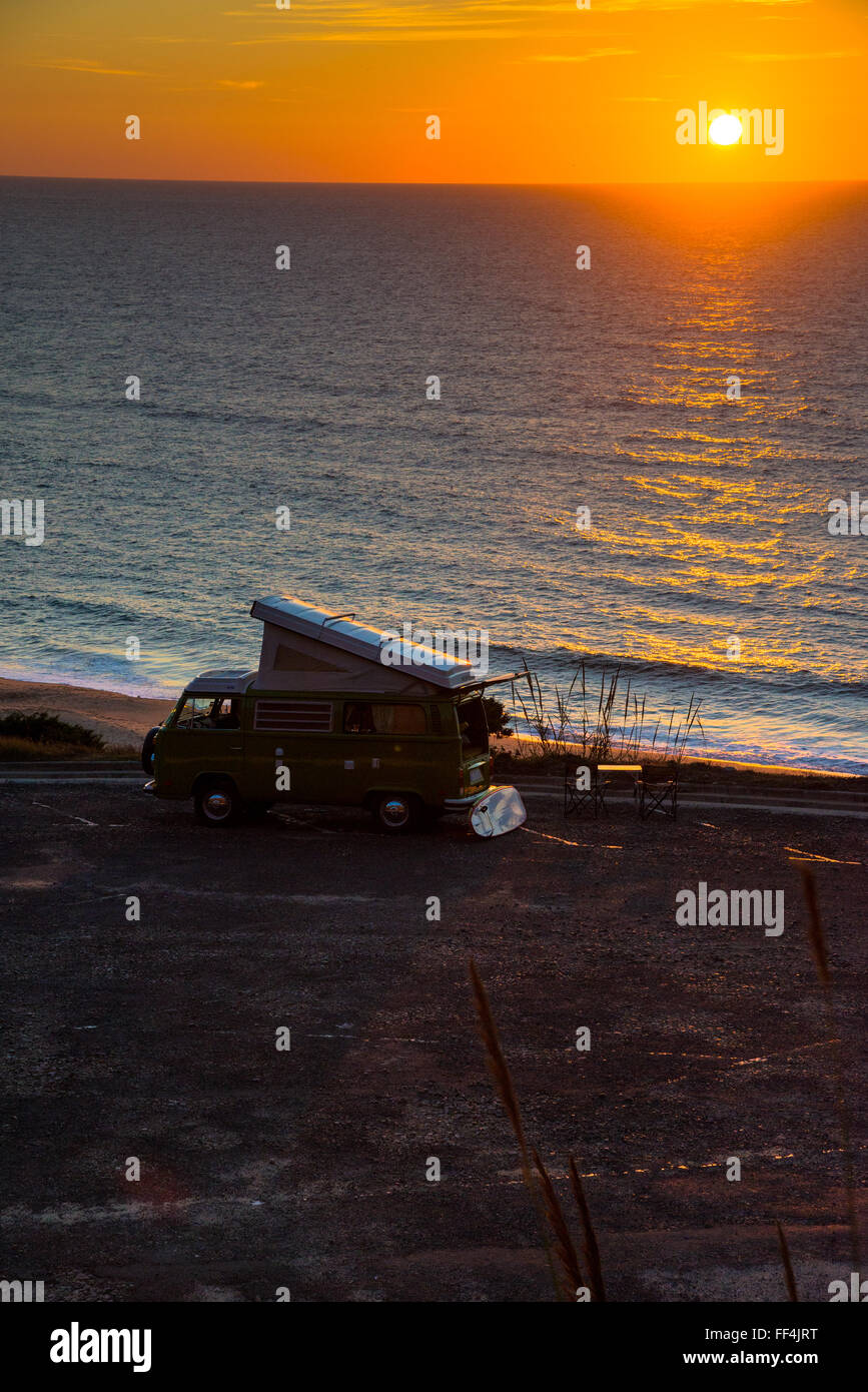 vw camper at coast with sunset in portugal Stock Photo