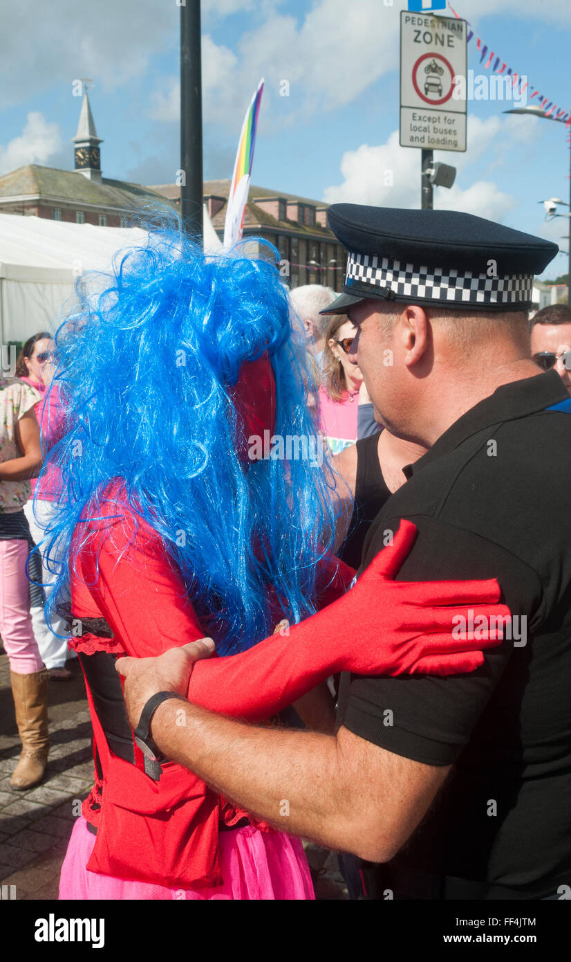 Policeman and dressed up participant  greeting each other at Cornwall Gay Pride, in England Stock Photo