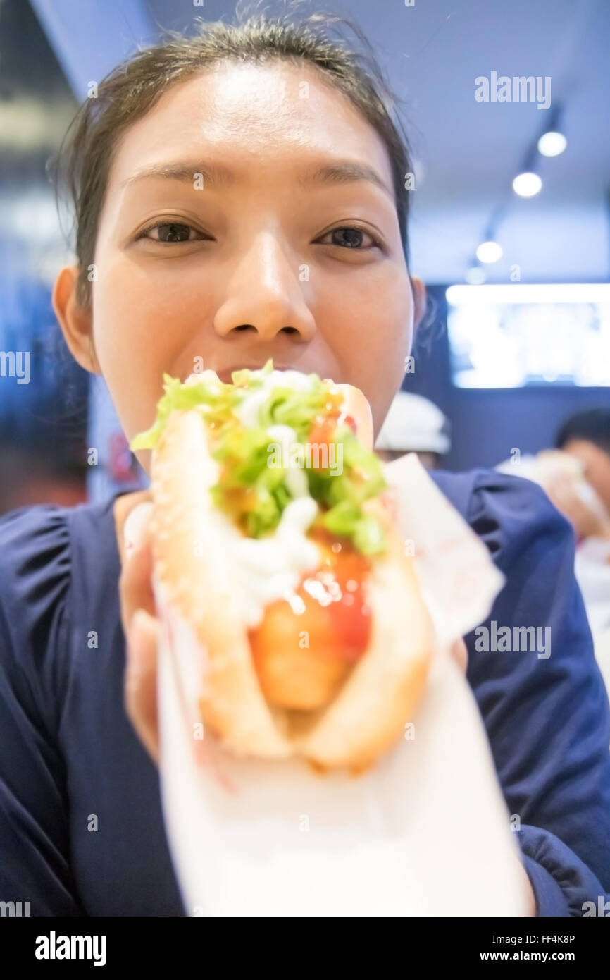 Portrait of a woman eating a hot dog Stock Photo