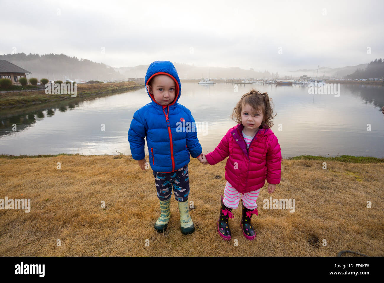 Brother and sister holding hands in this siblings portrait of two