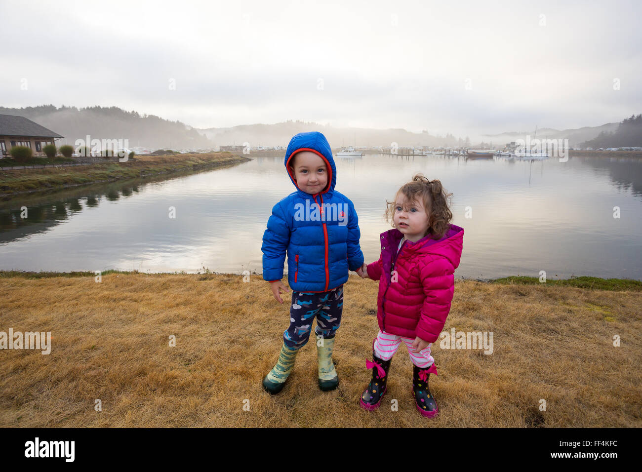 Brother and sister holding hands in this siblings portrait of two