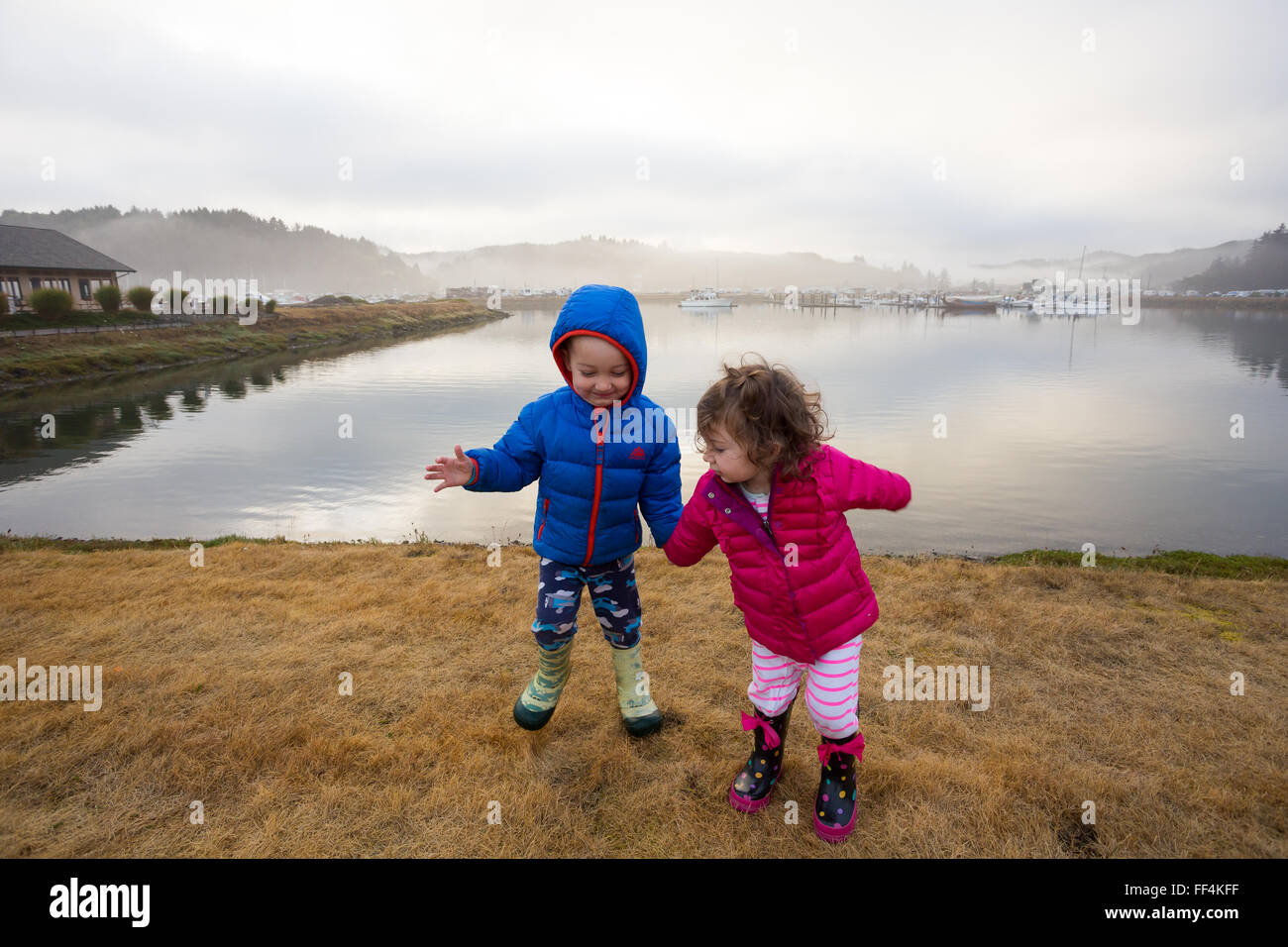 Brother and sister holding hands in this siblings portrait of two