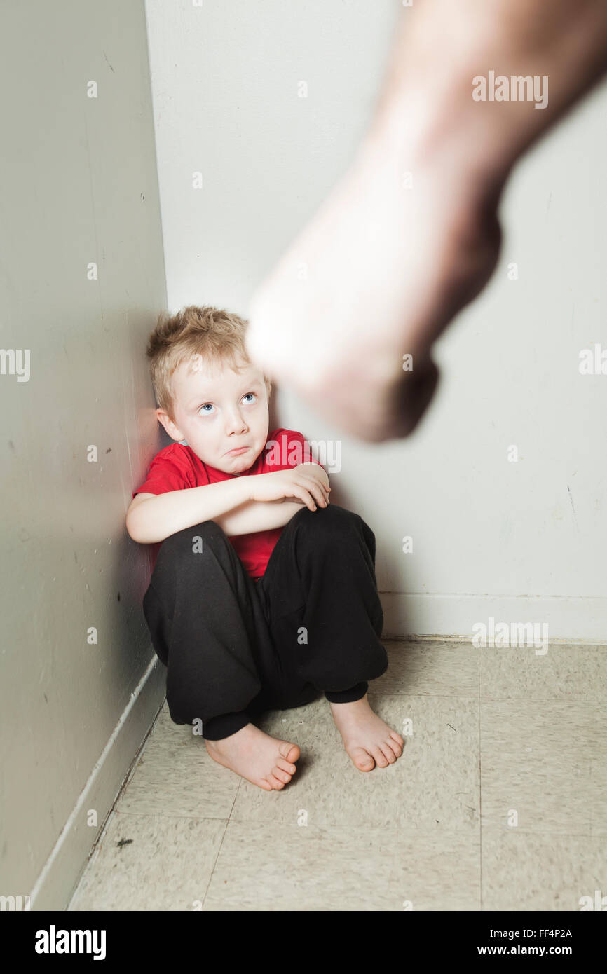 Boy sitting alone leaning on the wall Stock Photo
