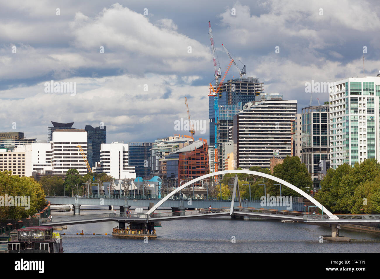 MELBOURNE - JAN 31 2016: View of Southbank footbridge and Yarra river from Princes bridge with office buildings and tower constr Stock Photo