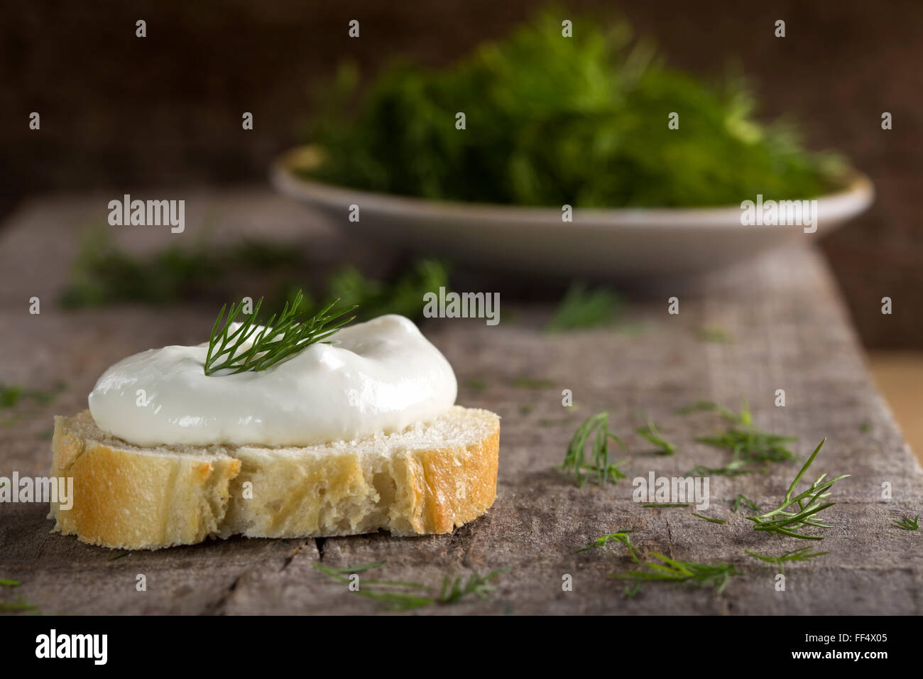 Healthy Organic Whole Grain Bagel with Cream Cheese over wooden background with dill Stock Photo