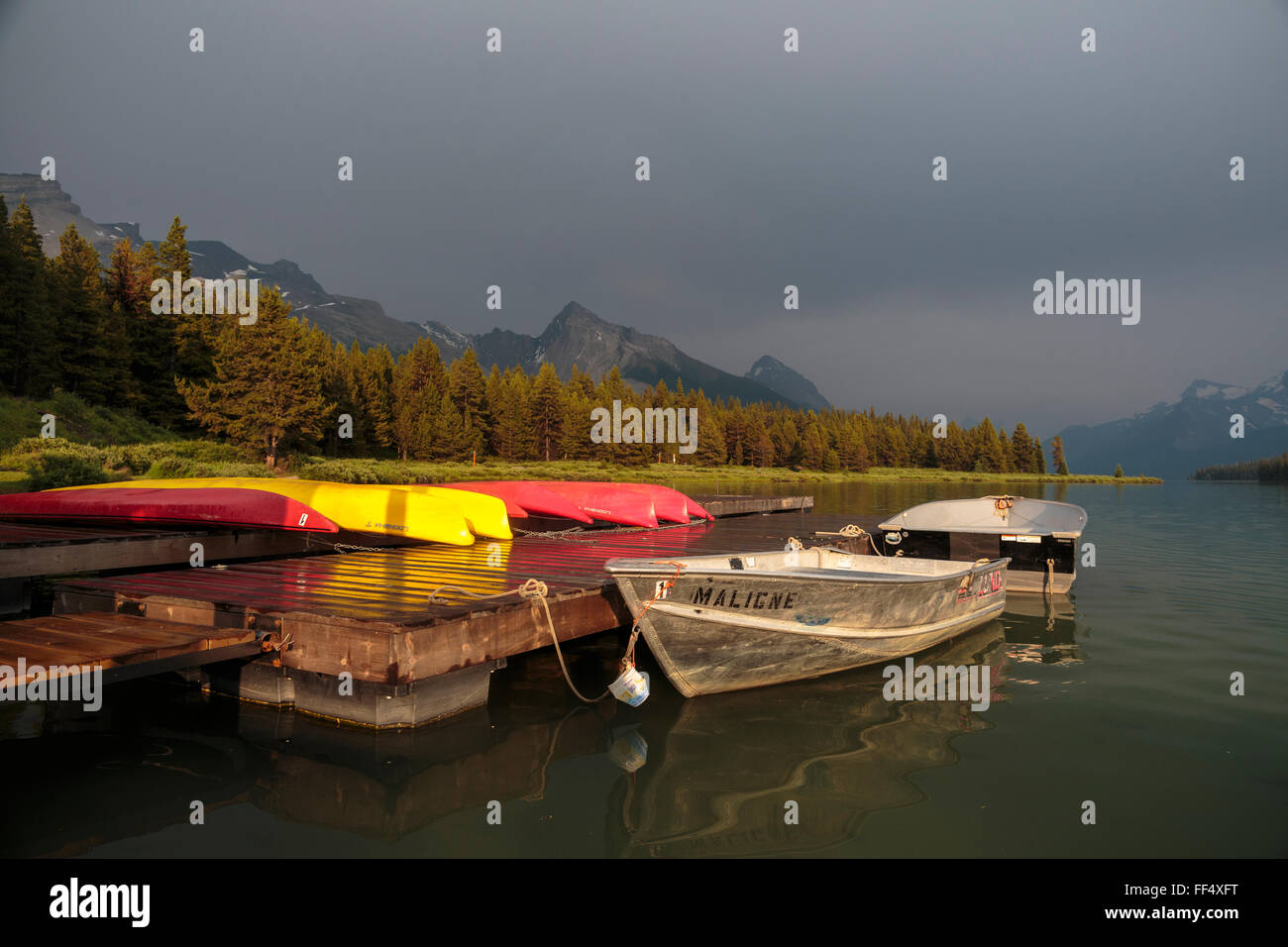 Evening light over Jasper National Park's Maligne Lake and boats available for rent at the historic Curly Phillips Boathouse. Stock Photo