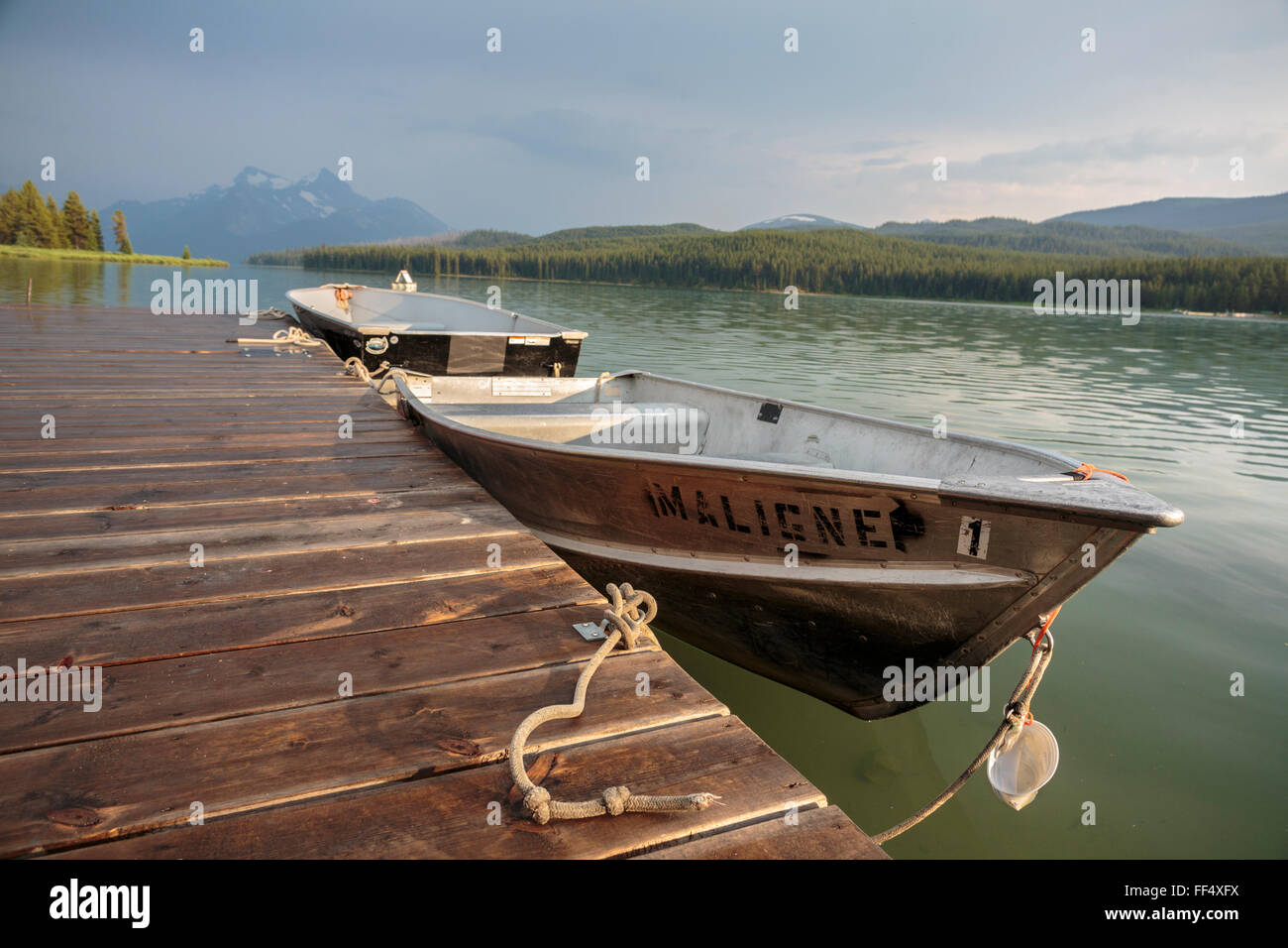 Evening light over Jasper National Park's Maligne Lake and boats available for rent at the historic Curly Phillips Boathouse. Stock Photo