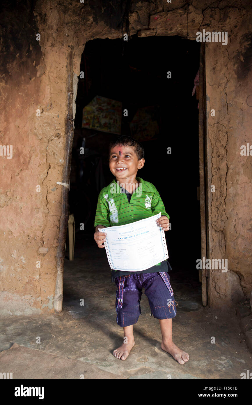 A young boy from the Dobhanda Nagar slum in Cuttack gets her birth certificates from the Urban Law centre run by the organisation CLAP. Committee for Legal Aid to Poor (CLAP) helps provide legal aid to the poorer communities in the Orissa district of India. Stock Photo