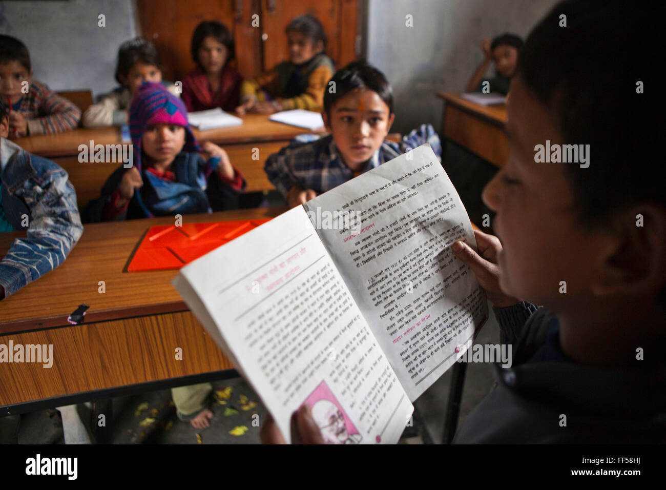 A young boy reading to his class in a lesson at the Alternate Learning Hub, Subhai, Himalayas, India. The school is organized and funded by the Pragya charity.  Pragya is a non-profit organization providing education and information services in high altitude areas in the Himalayas. Stock Photo