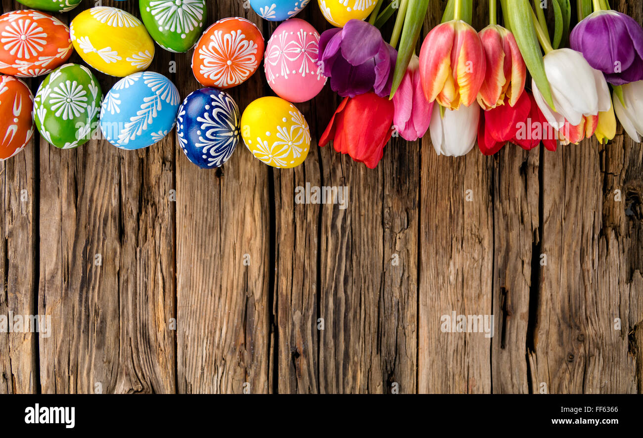 Easter eggs and tulips on wooden background Stock Photo - Alamy