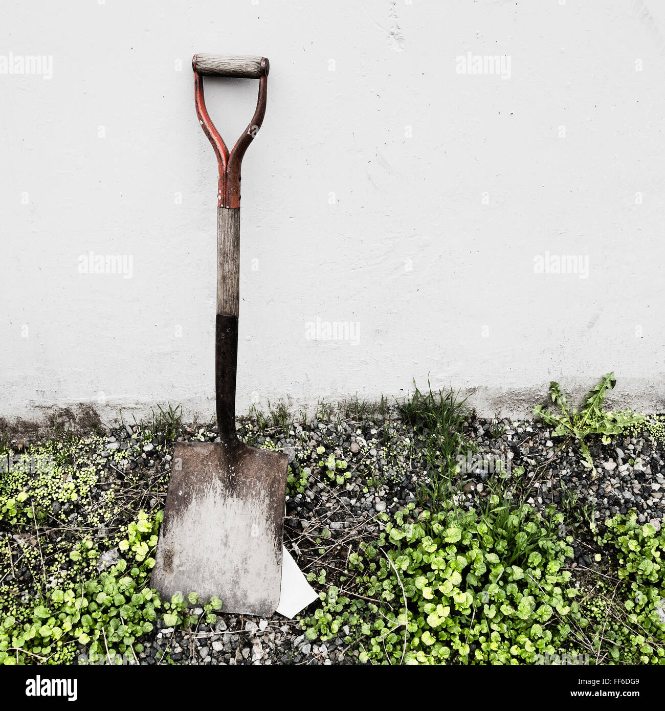 An old shovel propped against a wall. Stock Photo