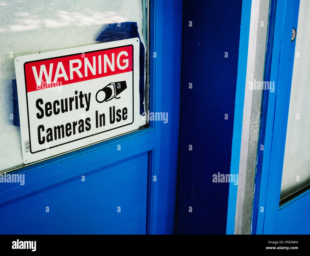 Security camera sign in a shop window. Stock Photo