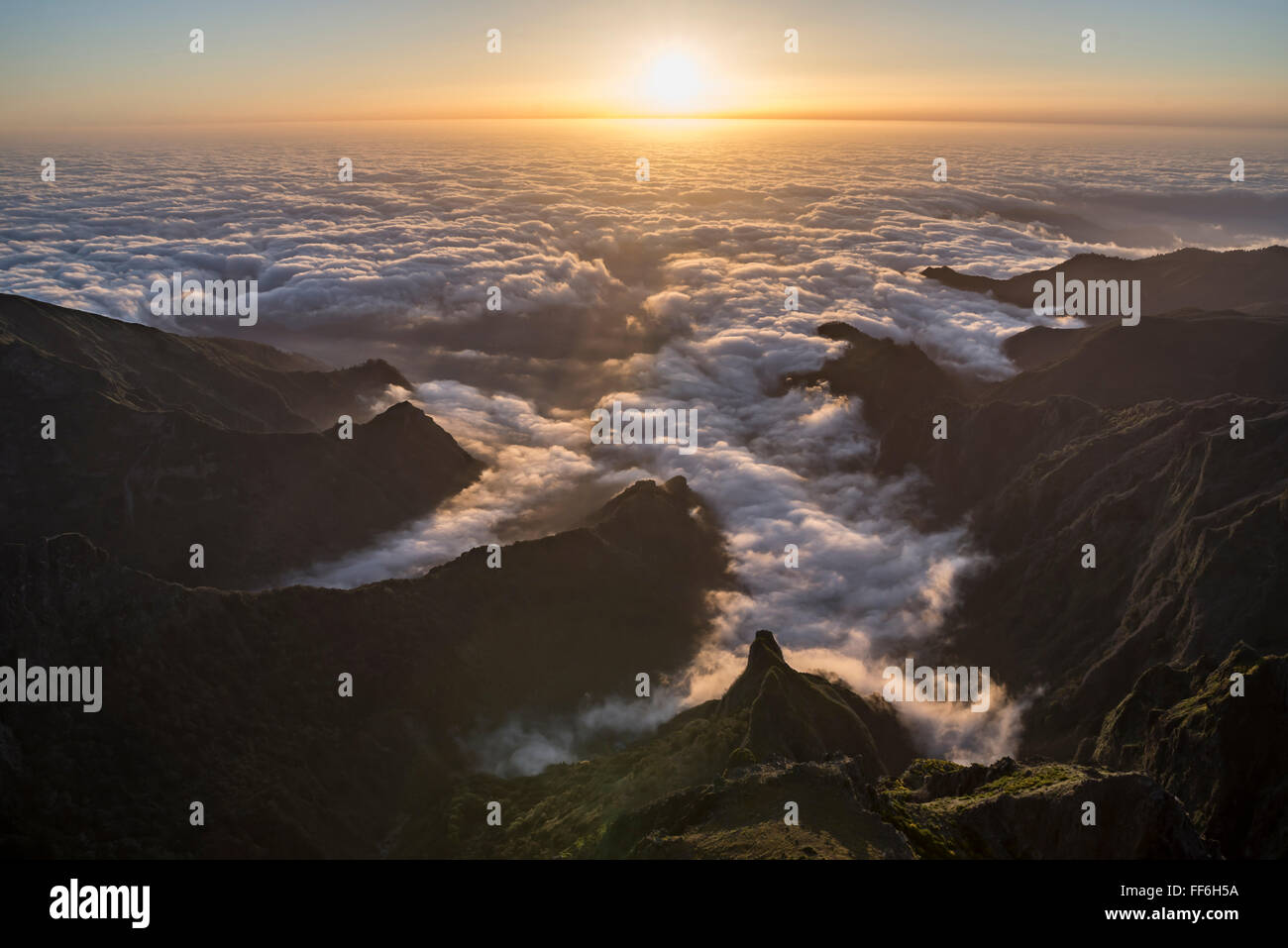 View from Pico do Ariero on sunrise over rugged valleys and deep canyons of the north coast of Madeira covered with clouds Stock Photo