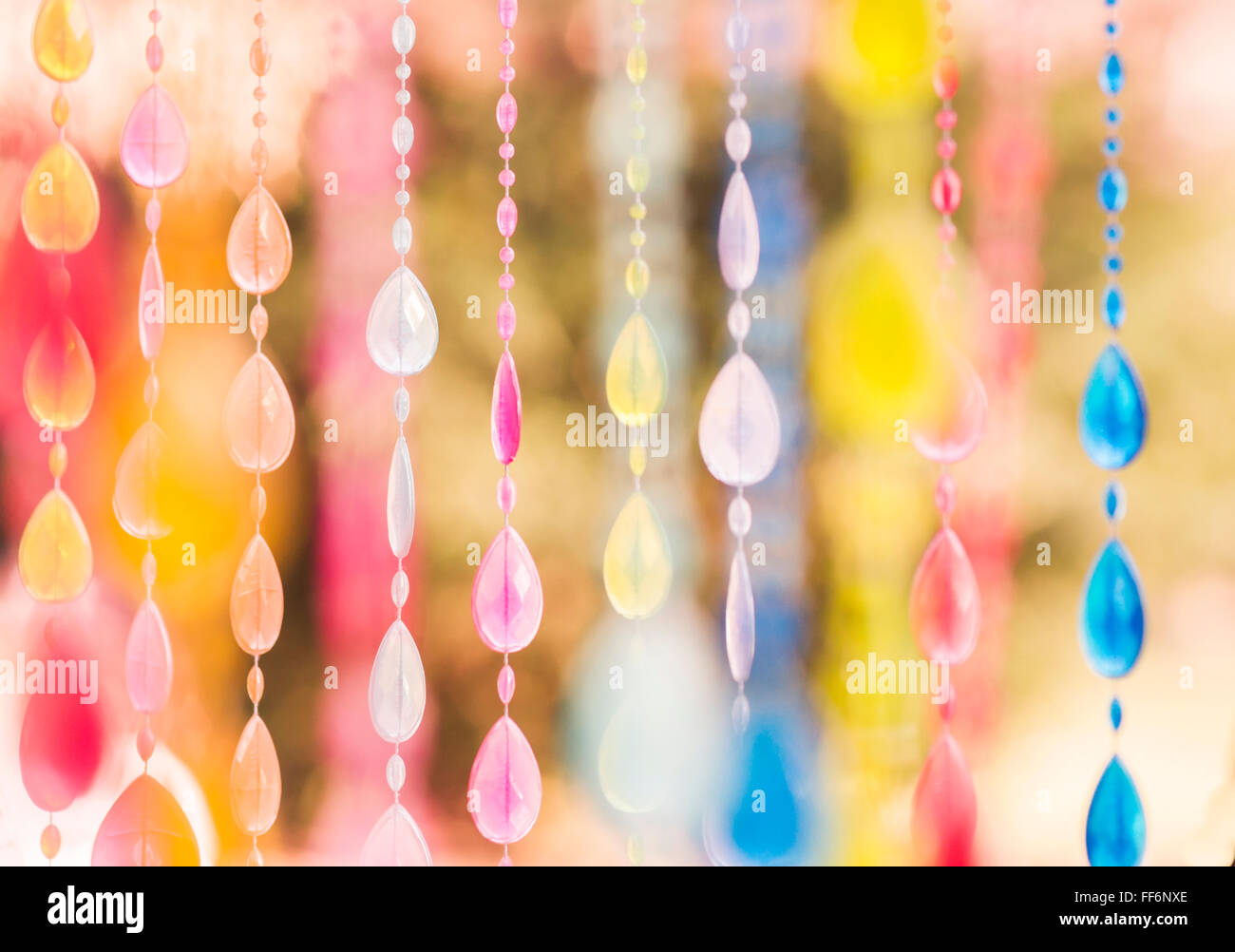 multicolor glass beads hanging from a tree in a park Stock Photo