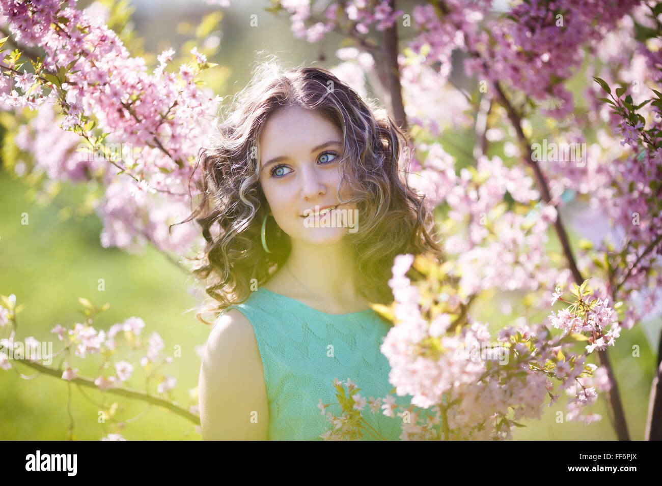 Portrait of beautiful young girl in the bushes magnolia Stock Photo