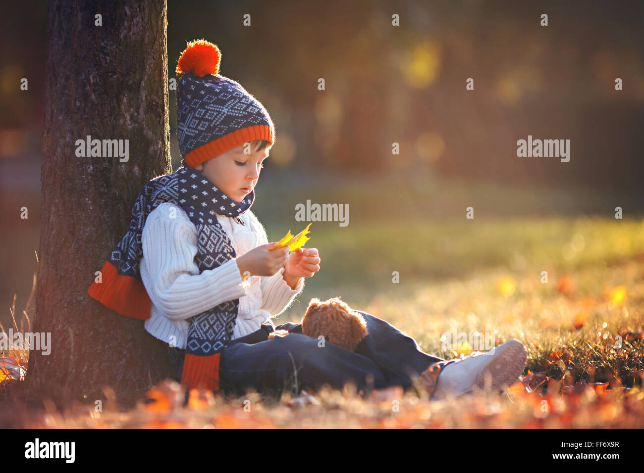 Adorable little boy with teddy bear in the park on an autumn day in the ...