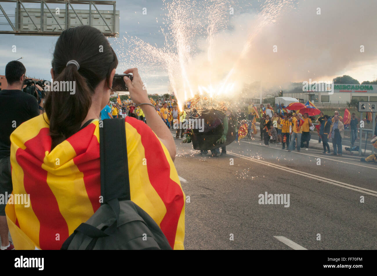 Wonan taking a phot to a firework at Catalan way demonstration, Catalonia, Spain. Stock Photo