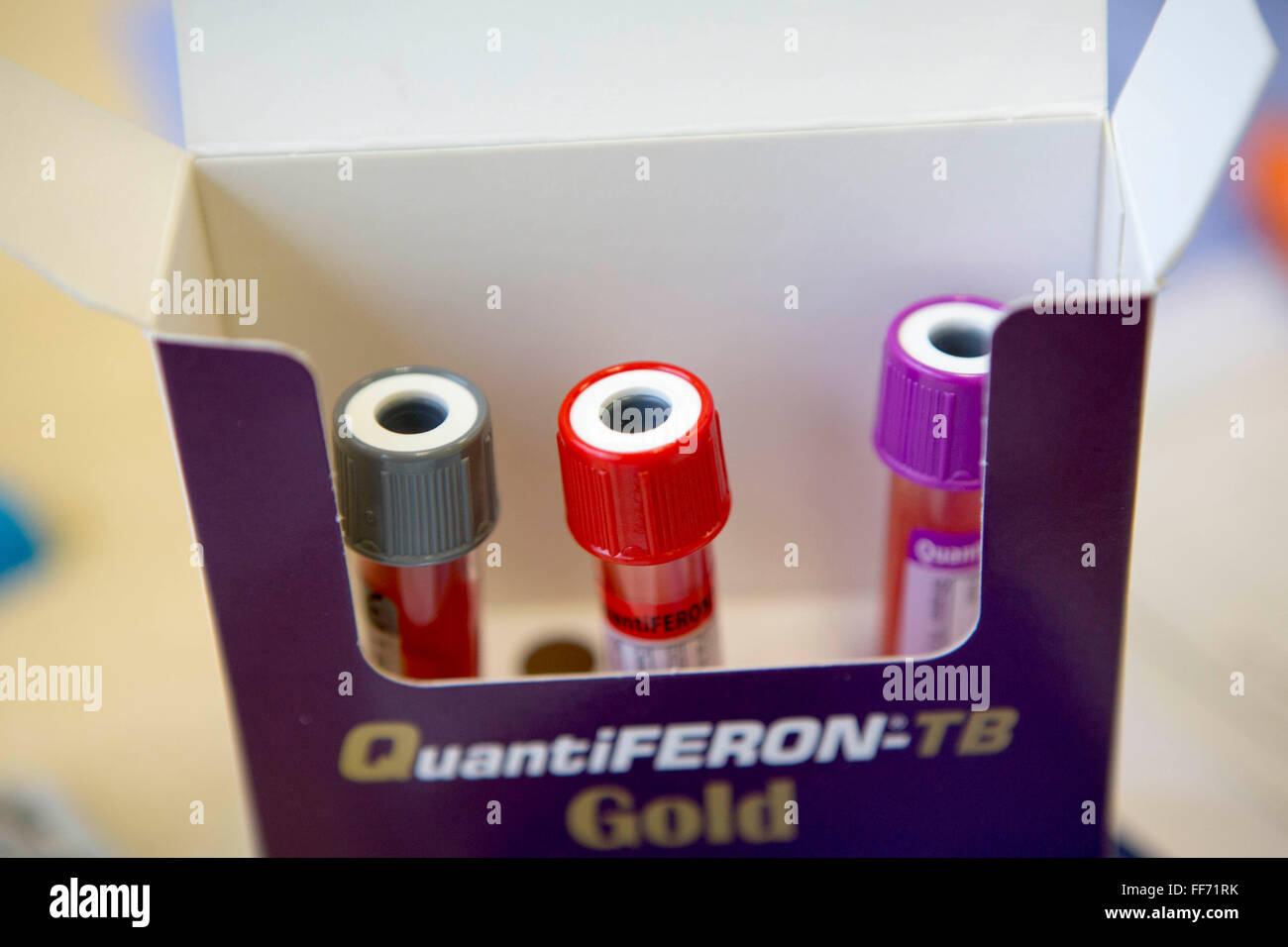 Three blood sample bottles packed in a QuantiFERON-TB Gold box.  The blood tests are used to detect latent TB infection in patients as is know as Interferon gamma release assay (IGRA). Stock Photo