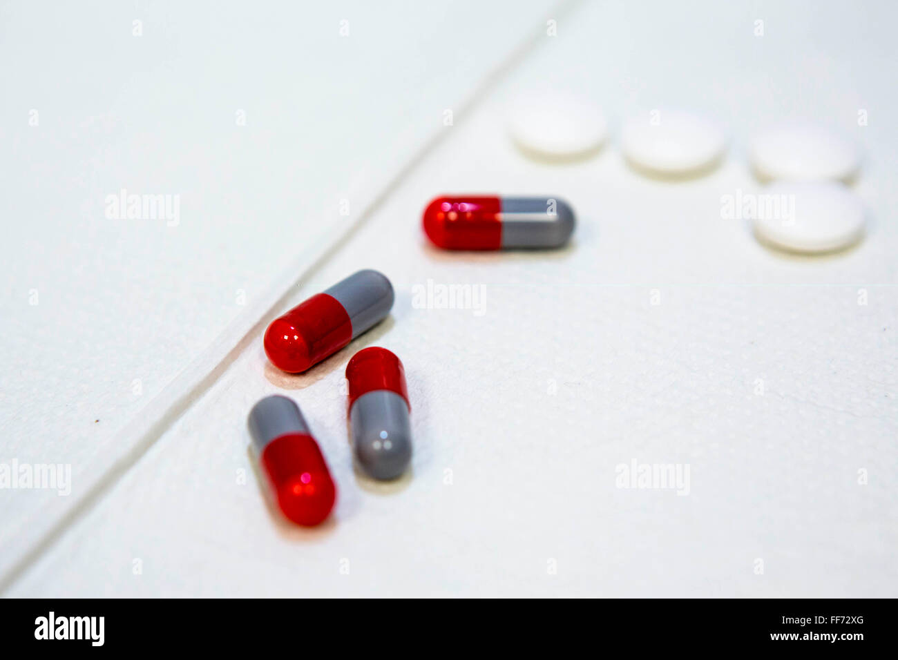 Medication tablets for tuberculosis in a TB clinic in London, England, UK. The red and grey tablets are Rifampicin and white tablets are Pyrazinamide.  They have to be taken together to treat the bacterial infection and prevent drug resistance. Stock Photo
