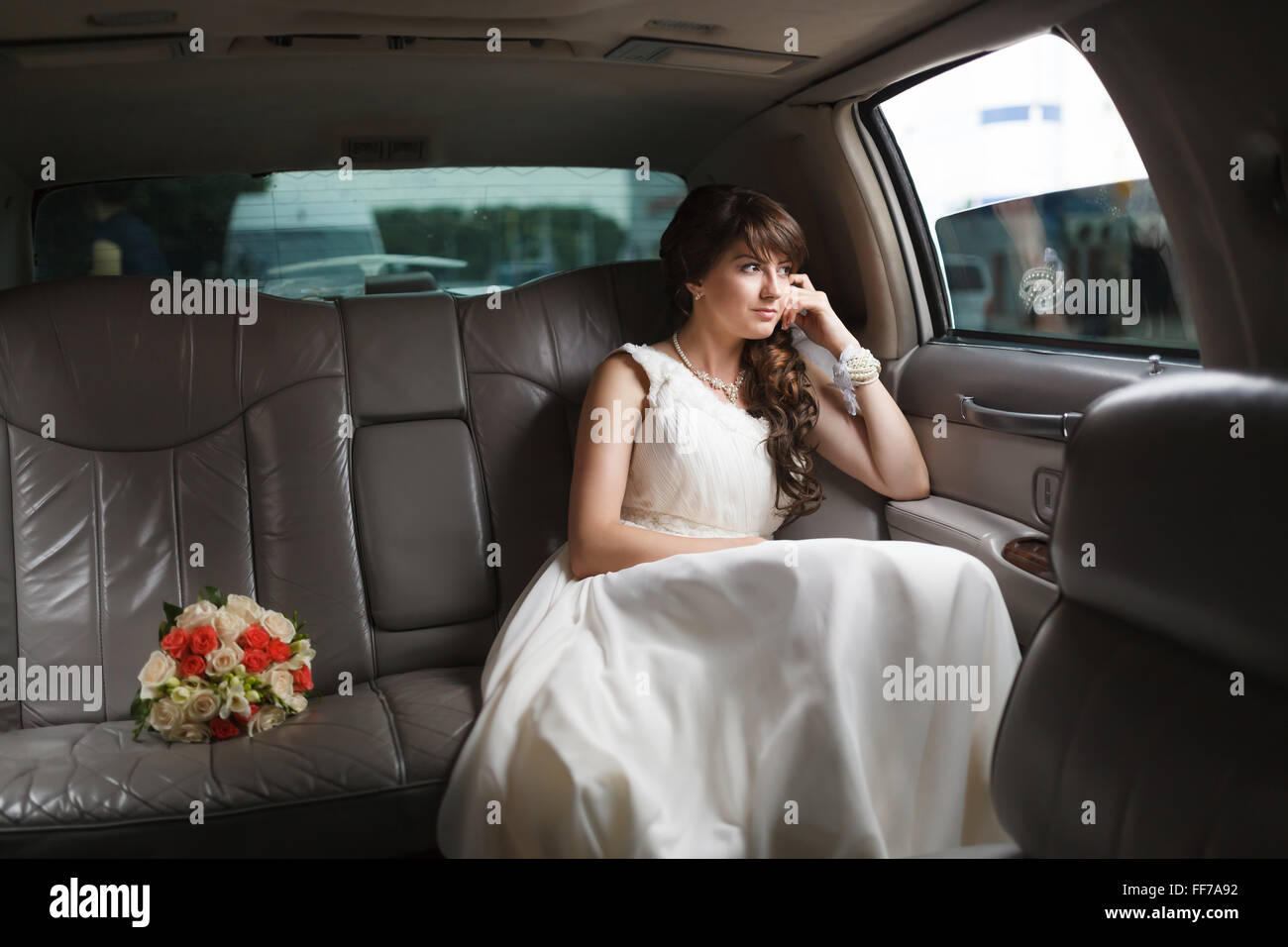 Smiling bride looking out the window of the car Stock Photo