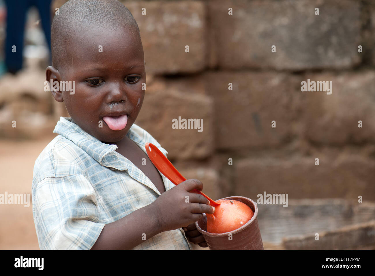 Mali, Africa - Portrait of black child washing some stuff in Africa Stock Photo
