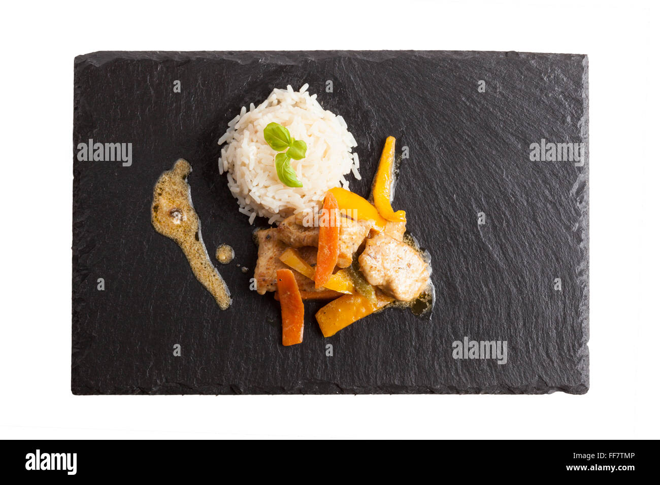 asian chicken dish on slate plate with rice Stock Photo