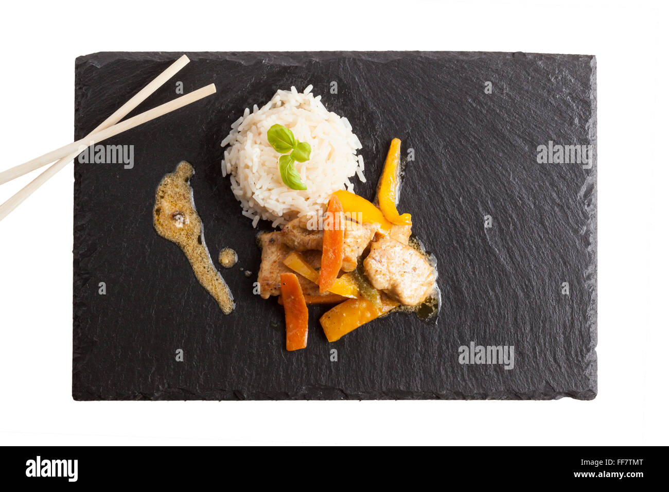 asian chicken dish on slate plate with rice Stock Photo