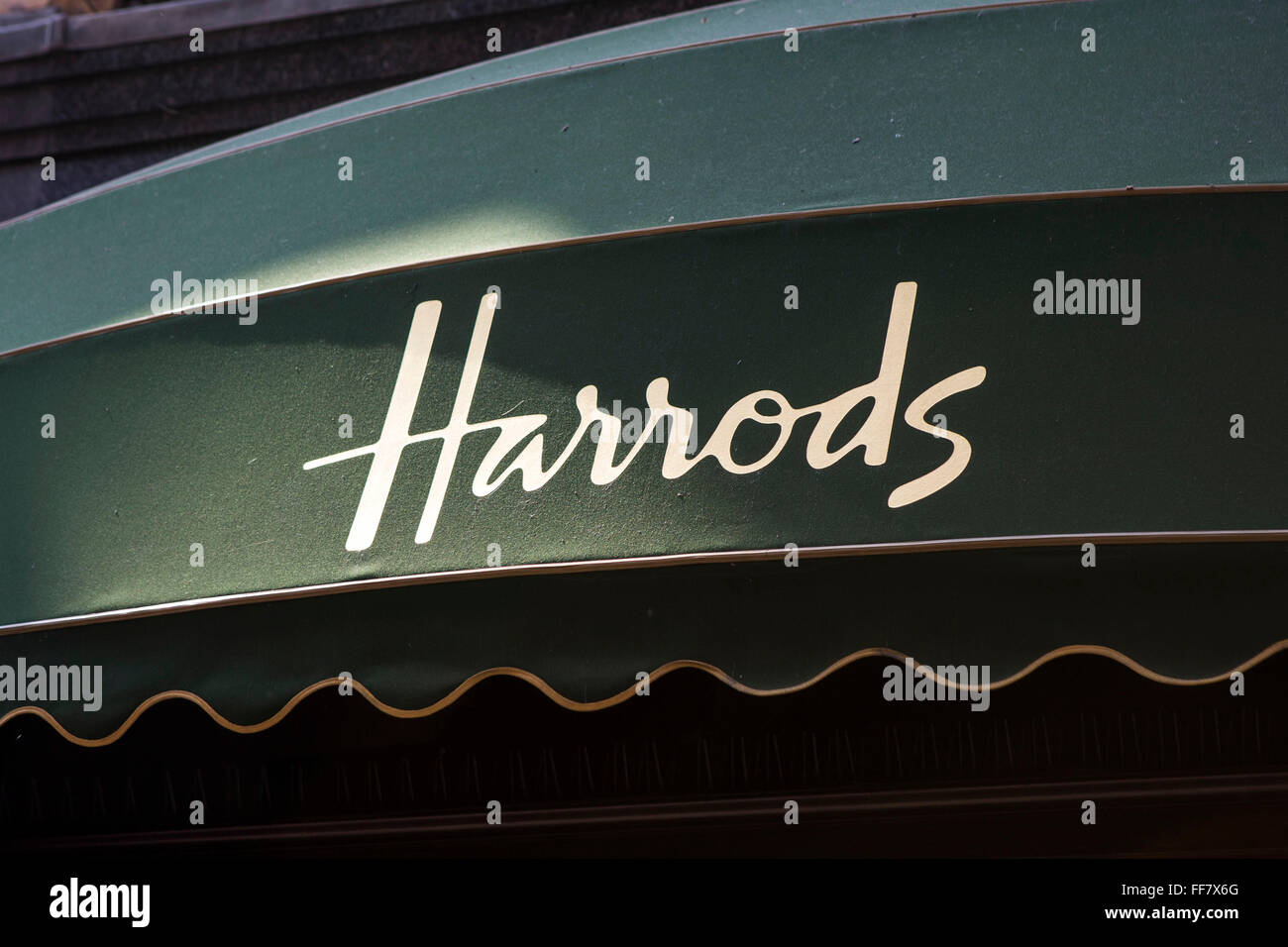 The world famous Harrods logo printed on a green awning over the Harrods department shop window, Knightsbridge, London, United Kingdom. Stock Photo