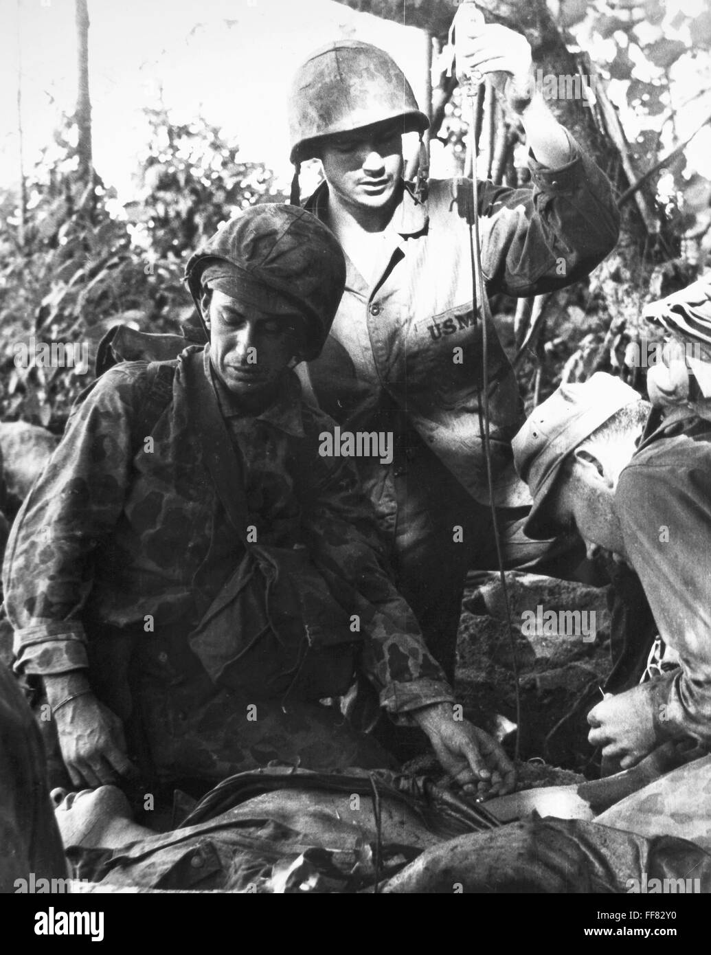 WORLD WAR II: MARINE, 1943. /nLaying on a crude stretcher, a marine receives blood plasma at Bougainville during World War II, November 1943. Stock Photo