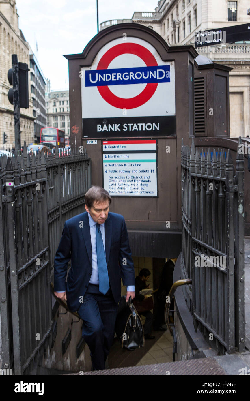 A British male walks up the steps of the subway to leave London Underground Bank Station, United Kingdom.  Bank station opened in 1900 and is named after the Bank of England.  It is served by the Central, Northern and Waterloo and City lines.  Due to is central City of London location, the station complex is the ninth-busiest on the London Underground network. Stock Photo