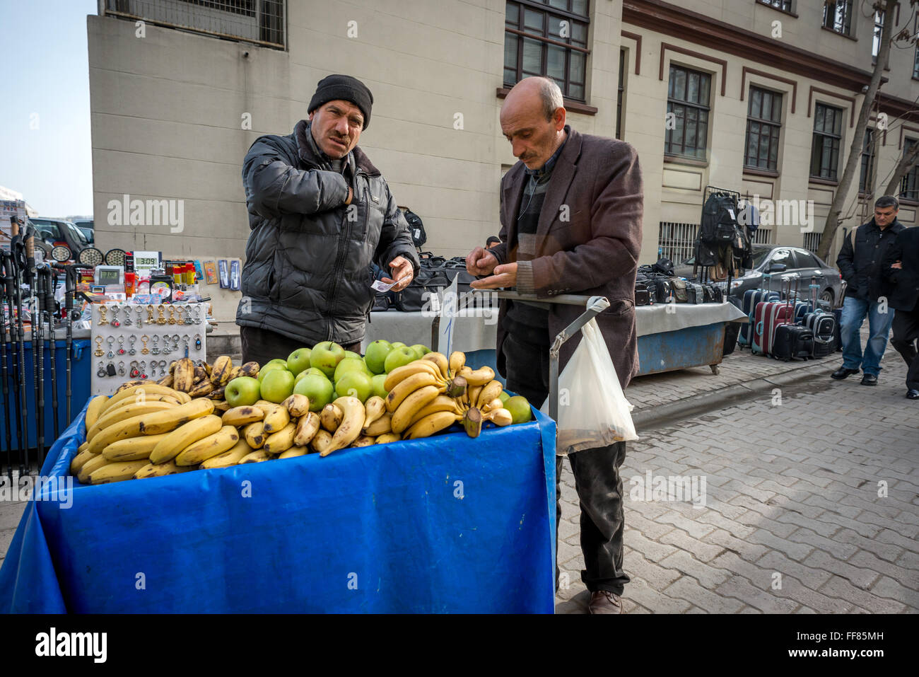 Two men discussing the price of fruit on a stall in Istanbul, Turkey. Stock Photo