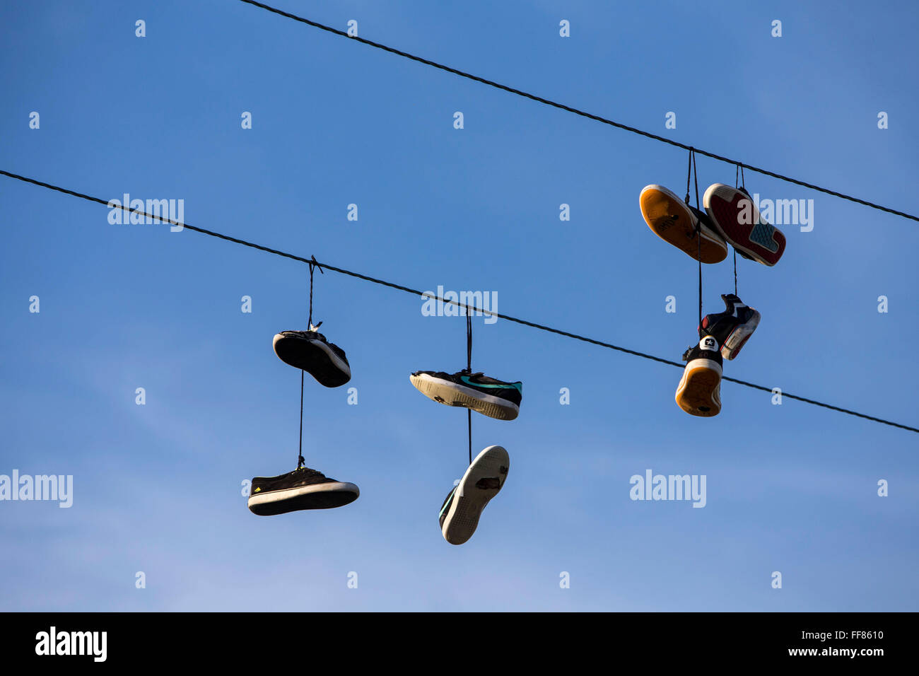 Pairs of shoes hanging on a wire. Wadebridge, Cornwall, UK. Shoe