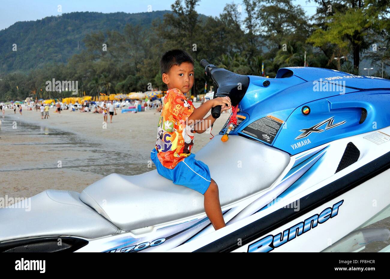 Phuket, Thailand Little Thai boy playing on a jet ski boat at Patong