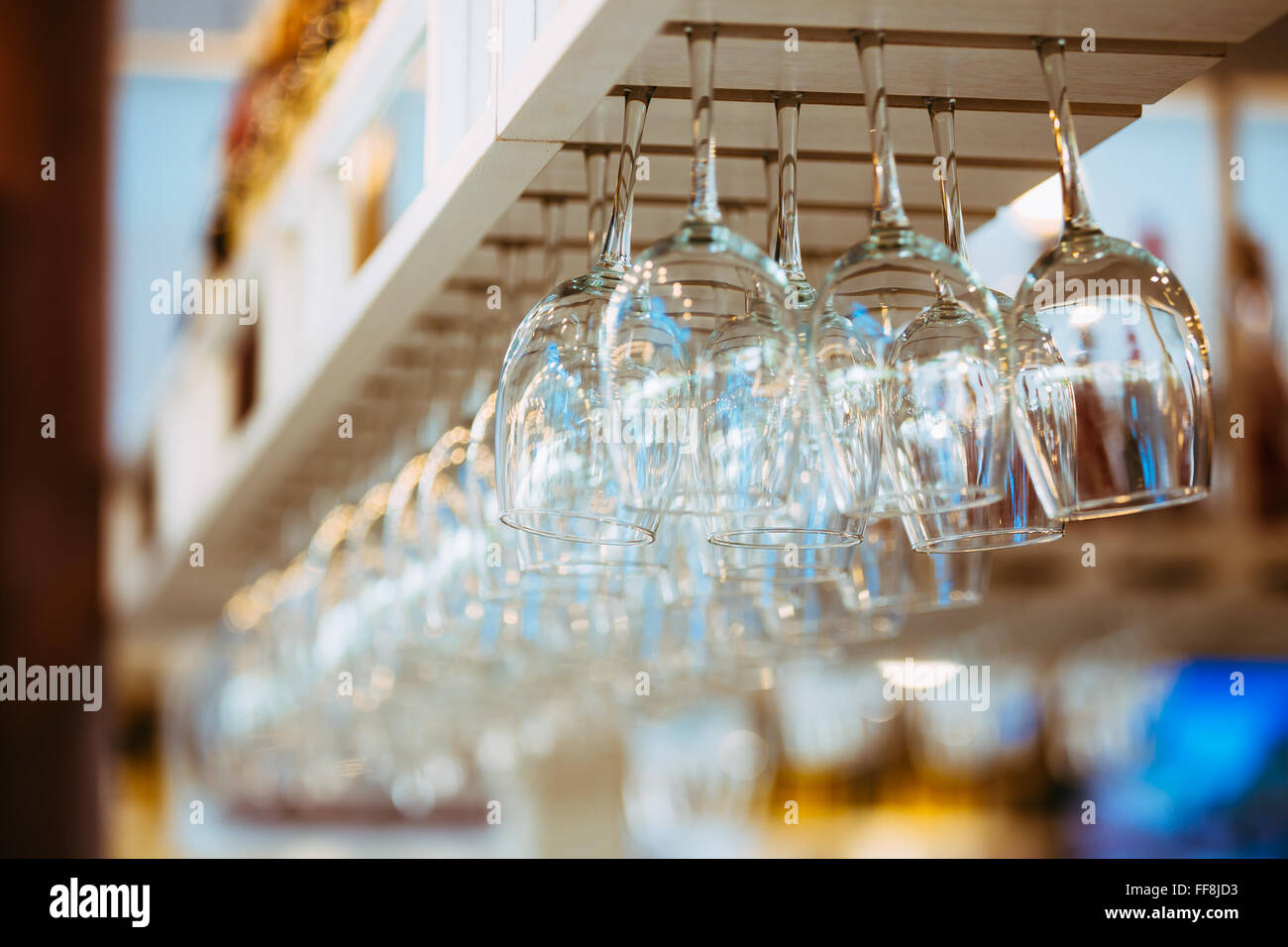 Glasses hanging over bar rack. Glasses for wine above a bar rack Stock Photo