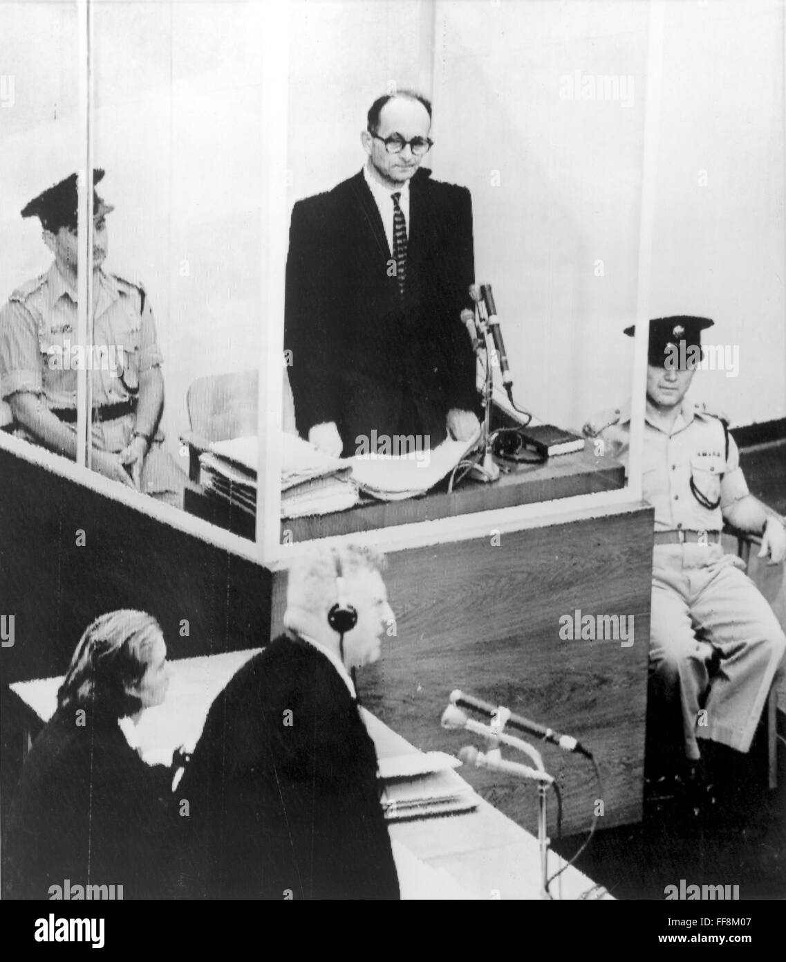 ADOLF EICHMANN (1906-1962). /nGerman Nazi leader and SS officer. Eichmann, enclosed in a bulletproof glass booth, giving evidence in his defense at his trial in Jerusalem on 20 June 1961. In the foreground is Eichmann's attorney, Robert Servatius. Stock Photo
