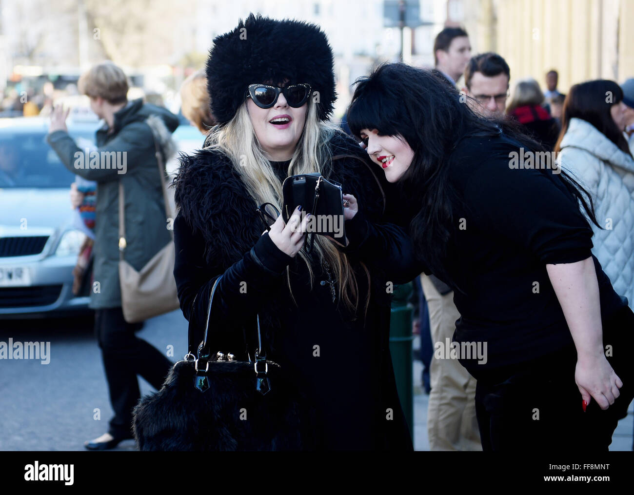Brighton, UK. 11th February, 2016. This couple of fashionable ladies are dressed to stay warm as the weather turns colder in Brighton today as they attended the University of Brighton Graduation Ceremony held in The Dome . The forecast is for colder weather to spread across Britain with snow predicted for next week  Credit:  Simon Dack/Alamy Live News Stock Photo
