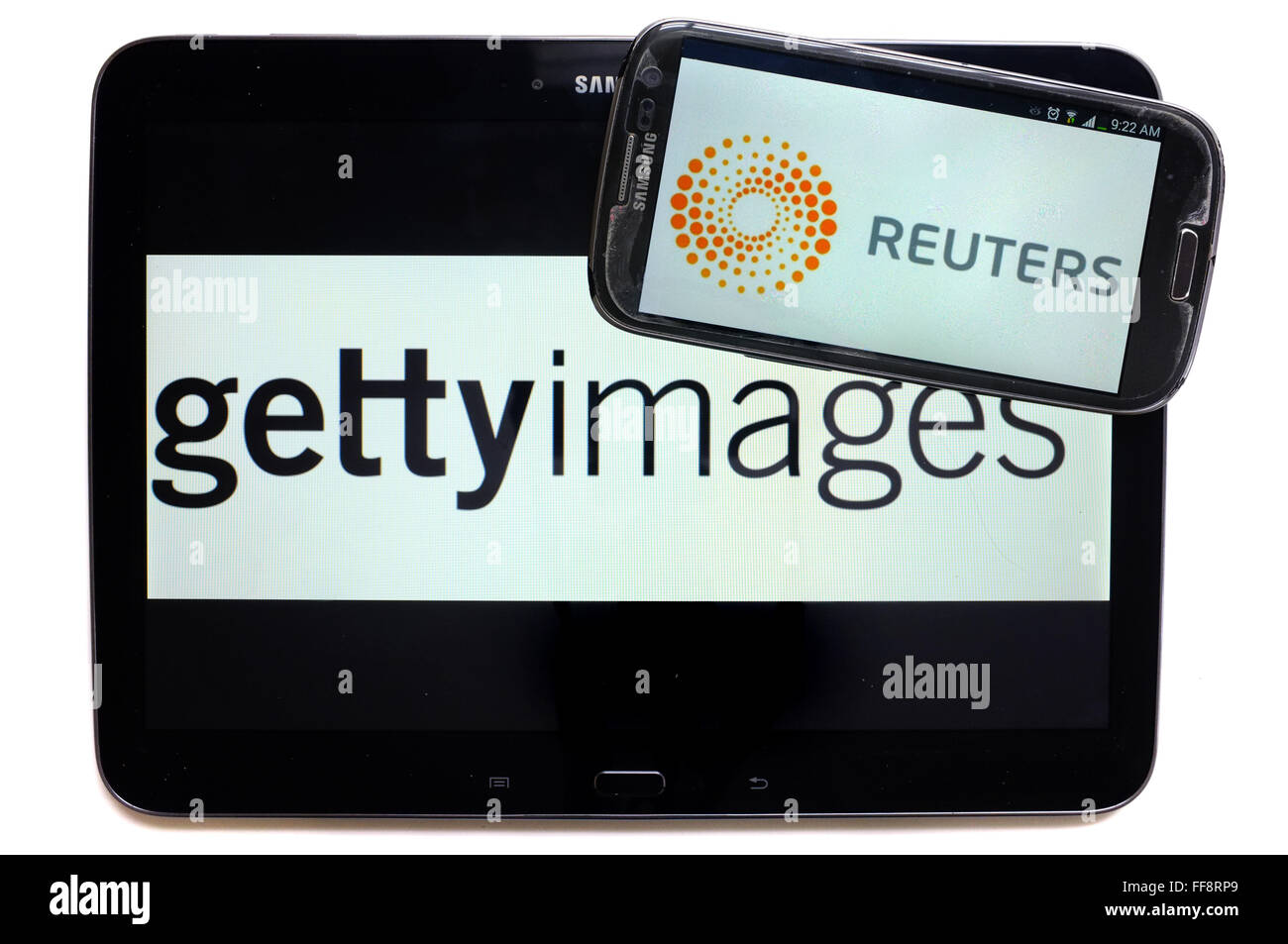 The news agencies getty images and Reuters on the screens of a tablet and a smartphone photographed against a white background. Stock Photo