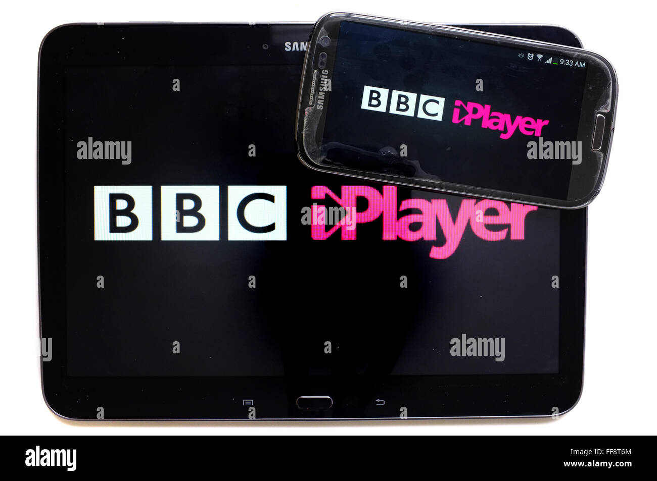 The BBC iPLayer logo on a smartphone screen and a tablet screen photographed against a white background. Stock Photo