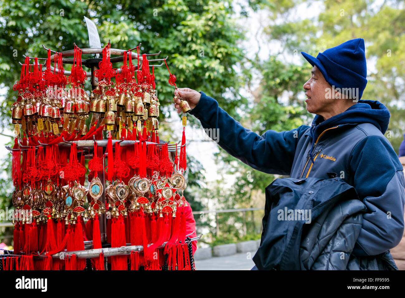 Asian man checking out Chinese bell souvenirs in China Stock Photo