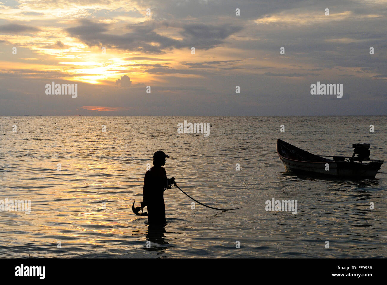 Thai fishing boat silhouetted against sunset, island Koh Phangan  / Koh Phangan, part of the Chumphon Archipelago in Thailand Stock Photo