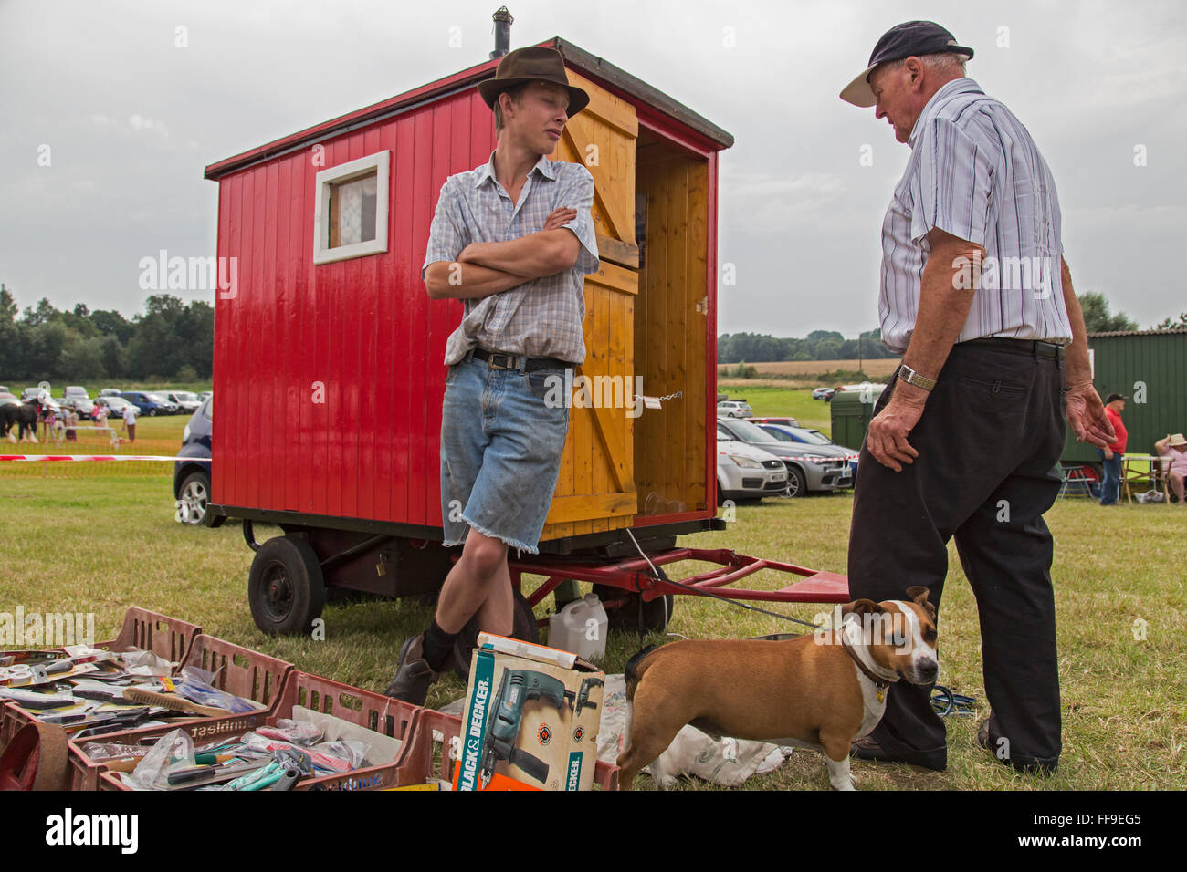 Two englishmen talk and a dog watches Stock Photo