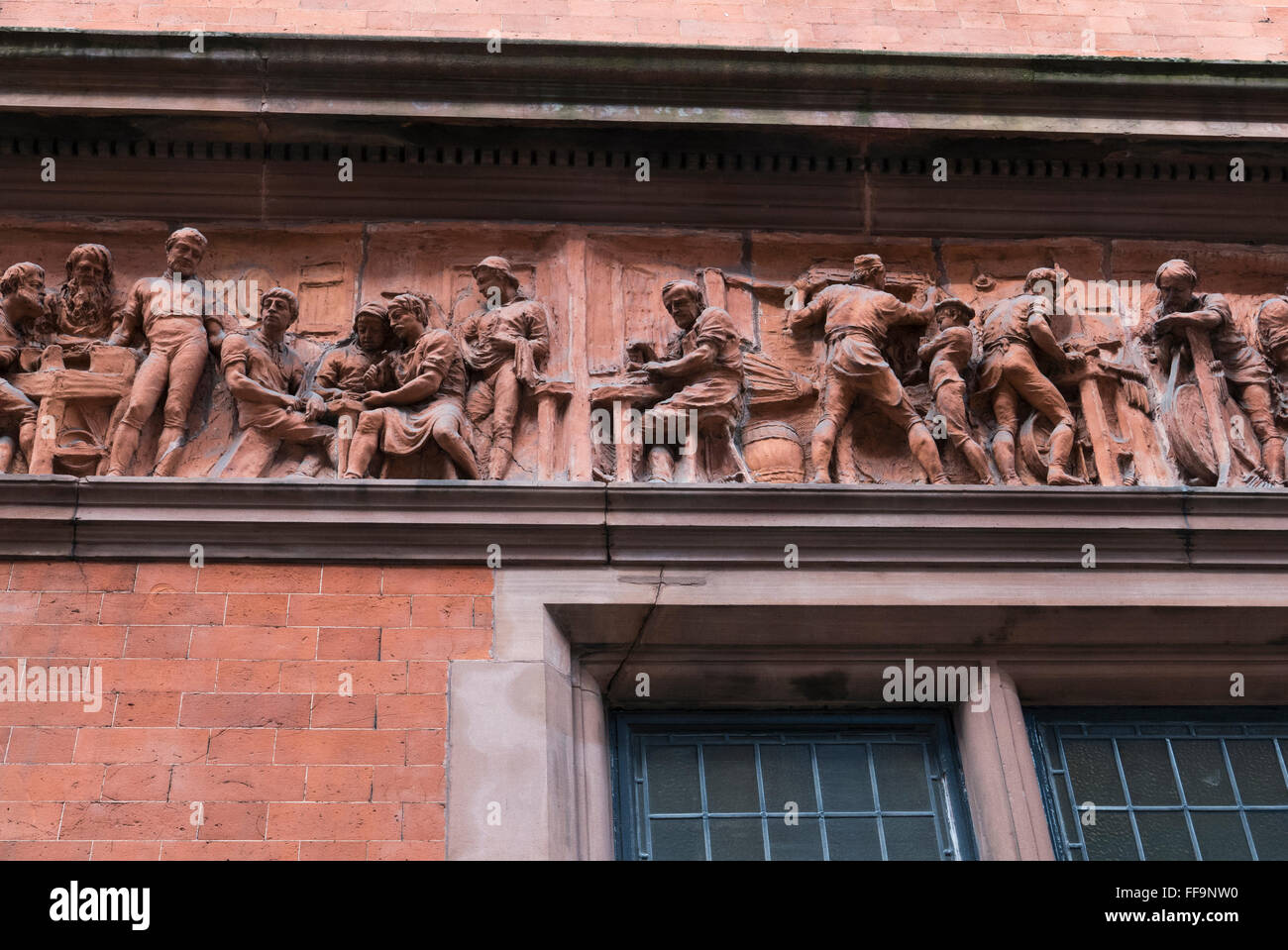 Stone carvings of men at work on the exterior wall of the Worshipful Company of Cutlers historic building, London. Stock Photo