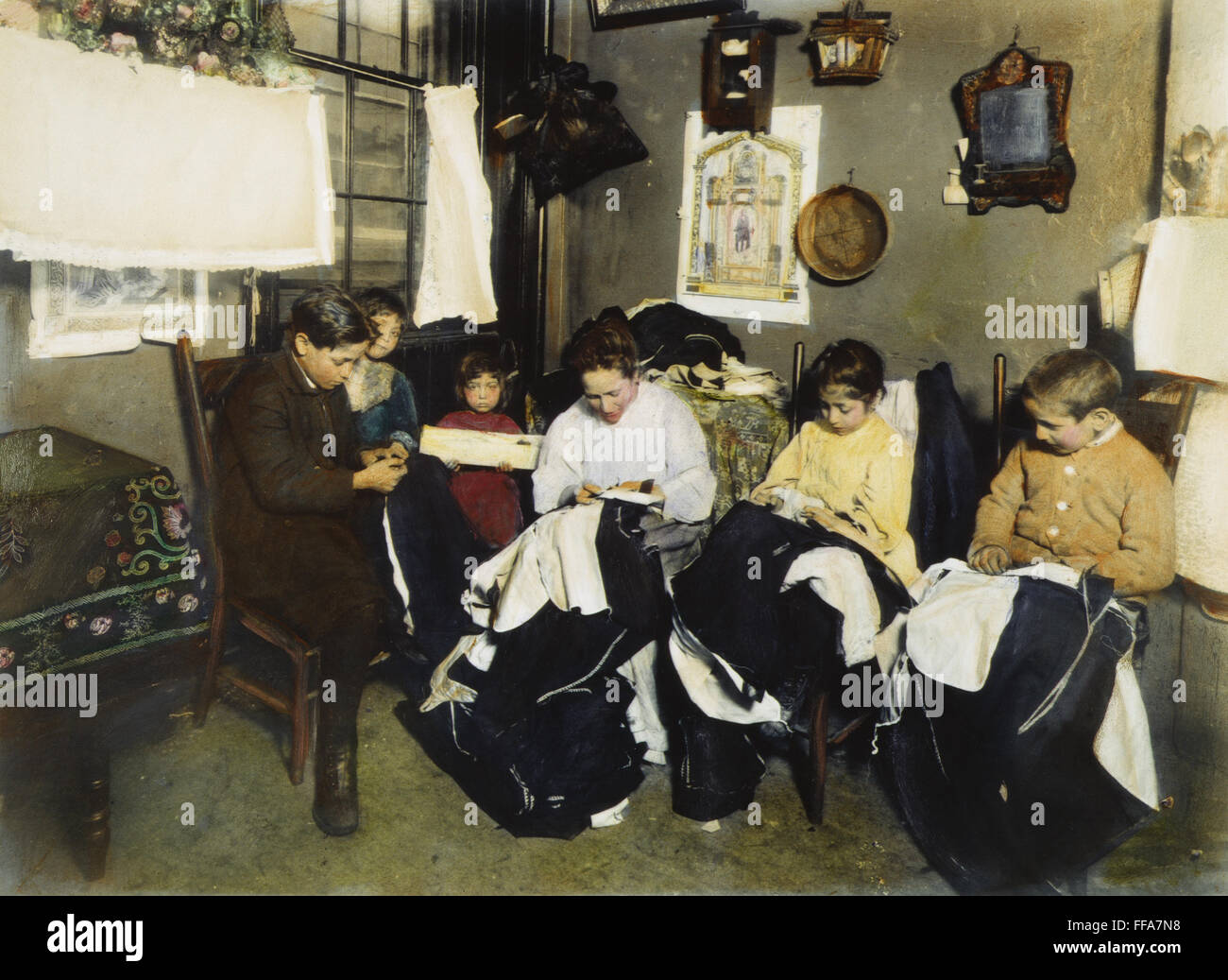 IMMIGRANTS: PIECEWORK. /nAn Italian immigrant family doing garment piecework in their New York City tenement home. Oil over a photograph, c1905. Stock Photo