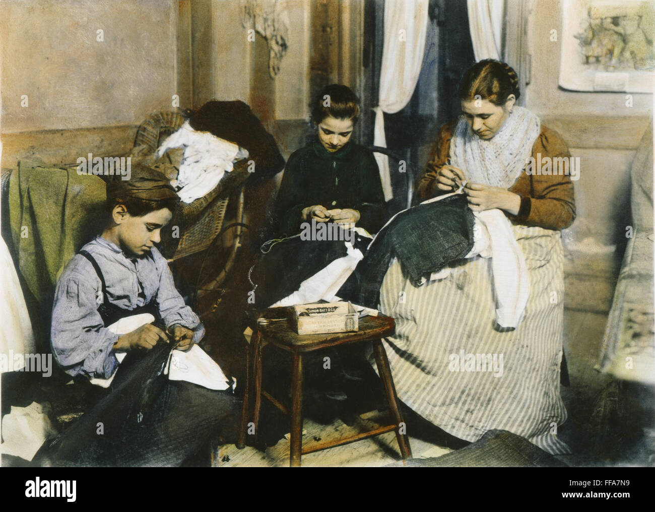 IMMIGRANTS FAMILY LABOR. /nAn immigrant family making men's trousers in their New York City tenement home. Oil over a photograph, c1910, by Lewis W. Hine. Stock Photo