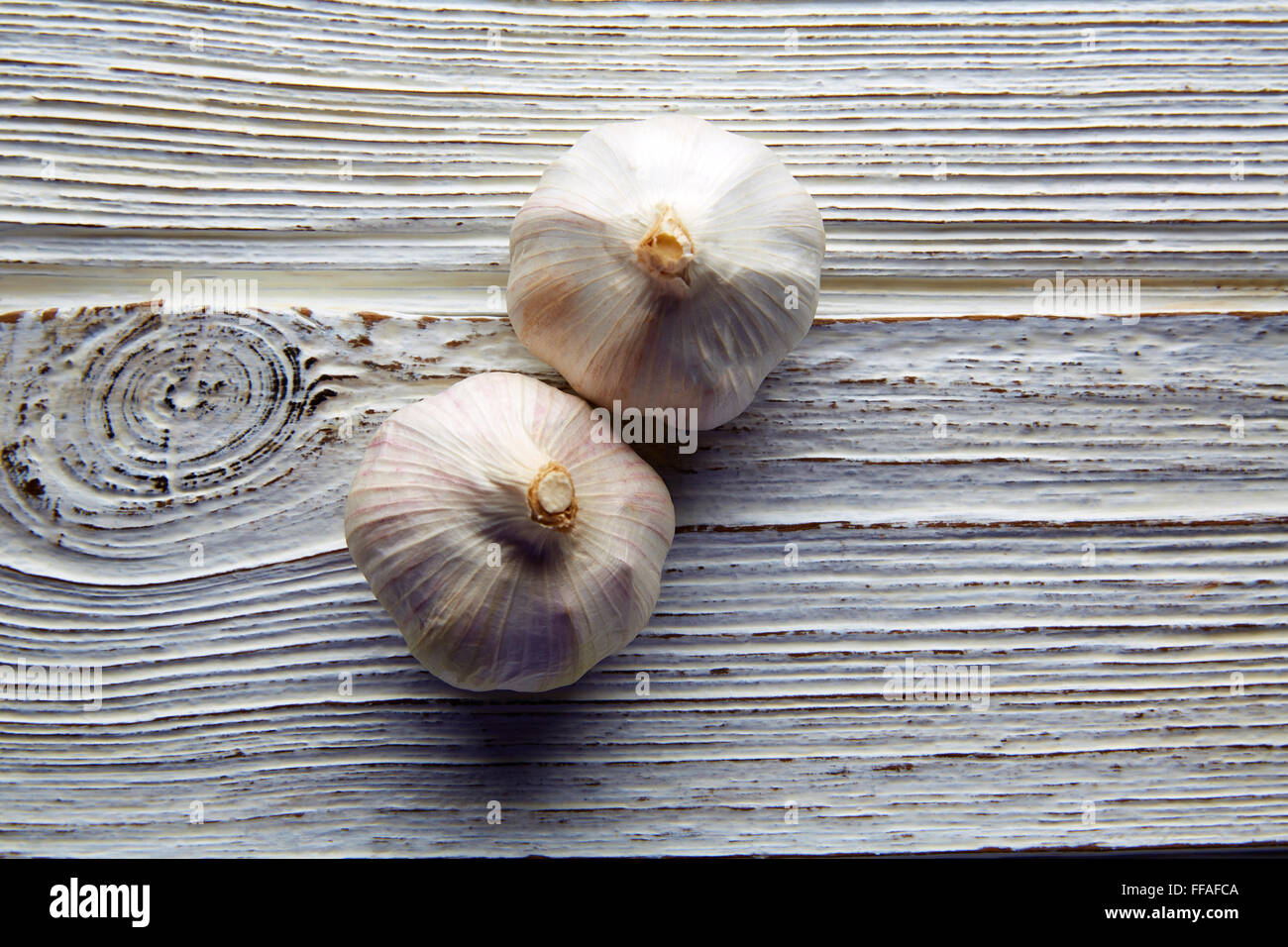 Garlic couple two garlics on white wood monochromatic background Stock Photo