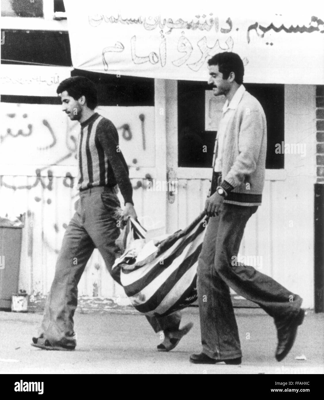TEHRAN U.S. EMBASSY, 1979. /nTwo Iranian men use the American flag to