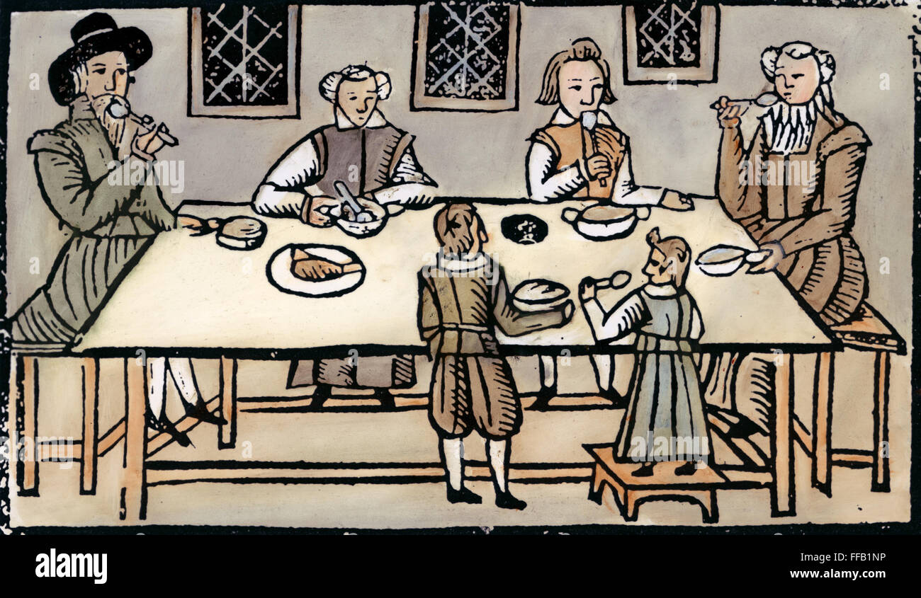 PURITAN FAMILY. /nA Puritan family at dinner. Woodcut, English, early 17th century. Stock Photo