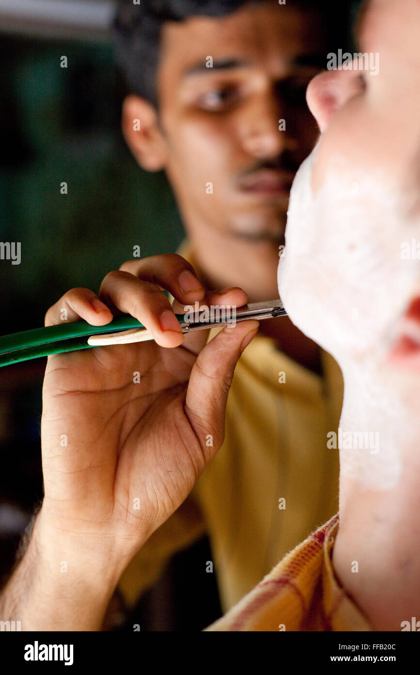 Man receives a shave at barber Stock Photo